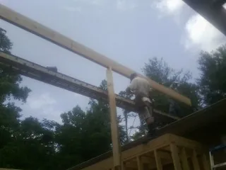Carpenter setting a ridge beam over a new addition frame — Ice Dam Removal by Roofing Brothers in Plain City