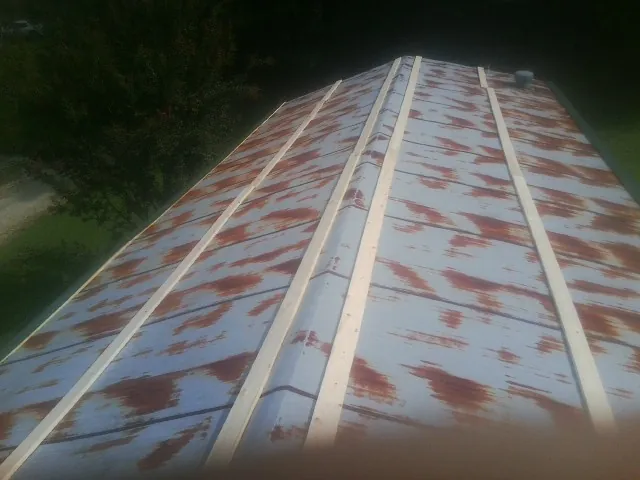 Rusted metal roof panels with new wood purlins before replacement — Storm Damage Roof Repair in Plain City by Roofing Brothers
