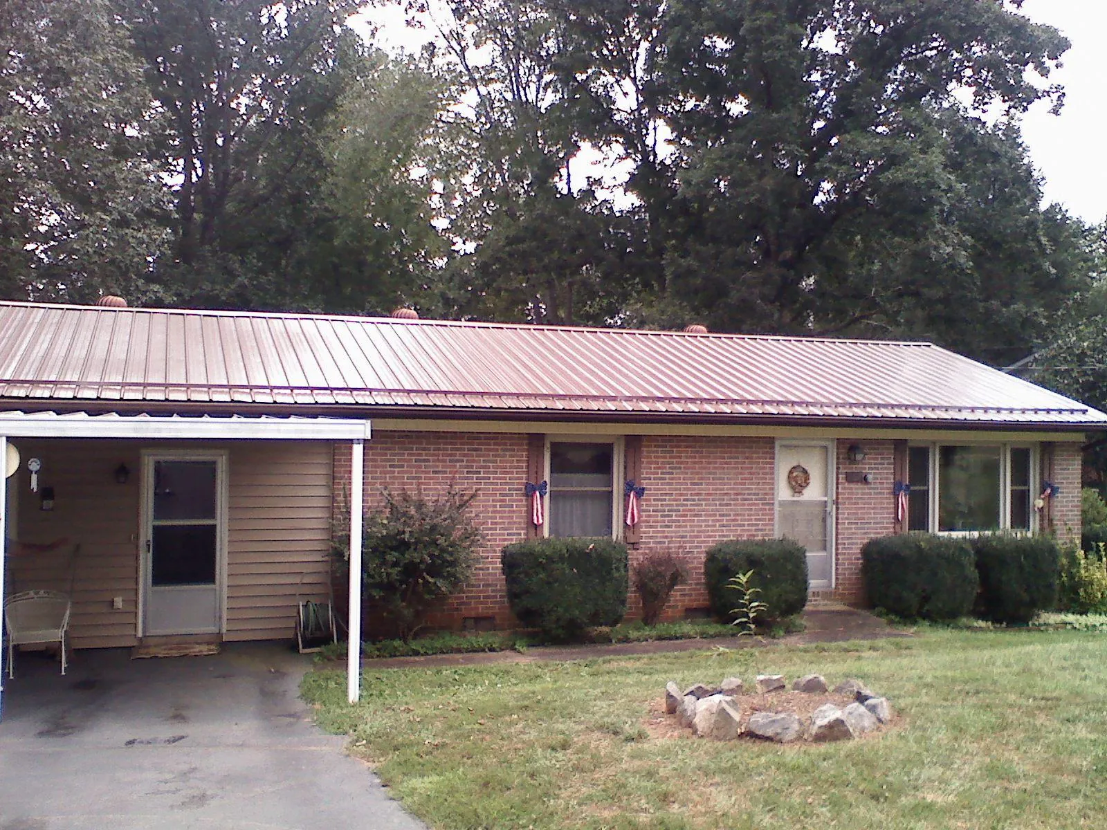 Bronze metal roof and carport on a brick ranch home — Roof Repair work by our crew in Plain City